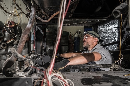 RV Repair Services at Mast Service Center in Etna Green, IL. image of technician servicing the engine on an RV in the bay