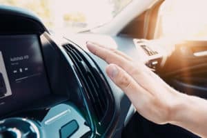 Why is My A/C Running But Not Cooling in My Car? | Mast Service Center Inc. in Etna Green, IN. Closeup image of a man’s hand checking the flow of air from a car air conditioner.