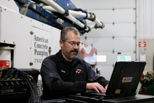 Fleet repair and maintenance services in Etna Green, IN at Mast Service Center. Image of mechanic using diagnostic computer while checking a local fleet truck in the shop.
