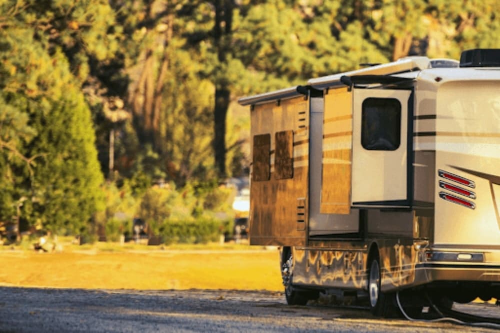 Top 5 Fall RV Travel Destinations: Where to Explore as the Leaves Change. RV parked in a scenic area during fall travel, showcasing a relaxed outdoor setting with trees in the background.