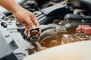 Cooling System Repair in Etna Green, IN At Mast Service Center. Close-up of a mechanic holding a radiator cap during a cooling system inspection.